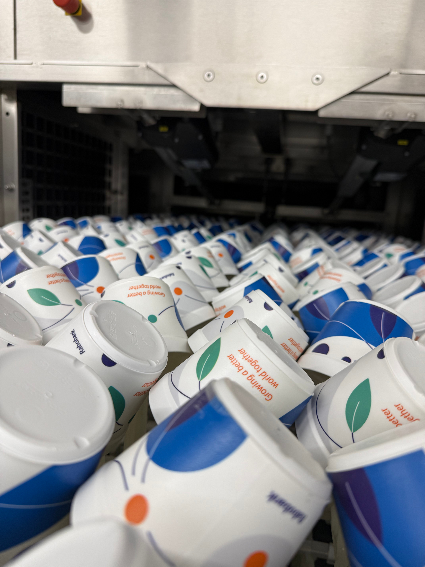 Herbruikbare koffiebekers worden professioneel gewassen in een vaatwasstraat